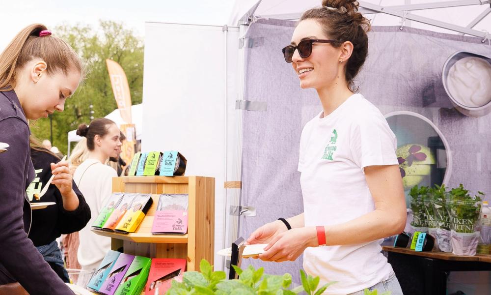 Dame fra Grønne Folk snakker med kunder