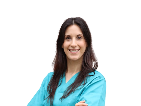 Smilende bilde av Claire Lucie Sonck med langt brunt hår og armer i kors, iført turkis veterinæruniform.