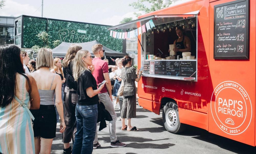 Bilde av folk som står i kø til food trucken
