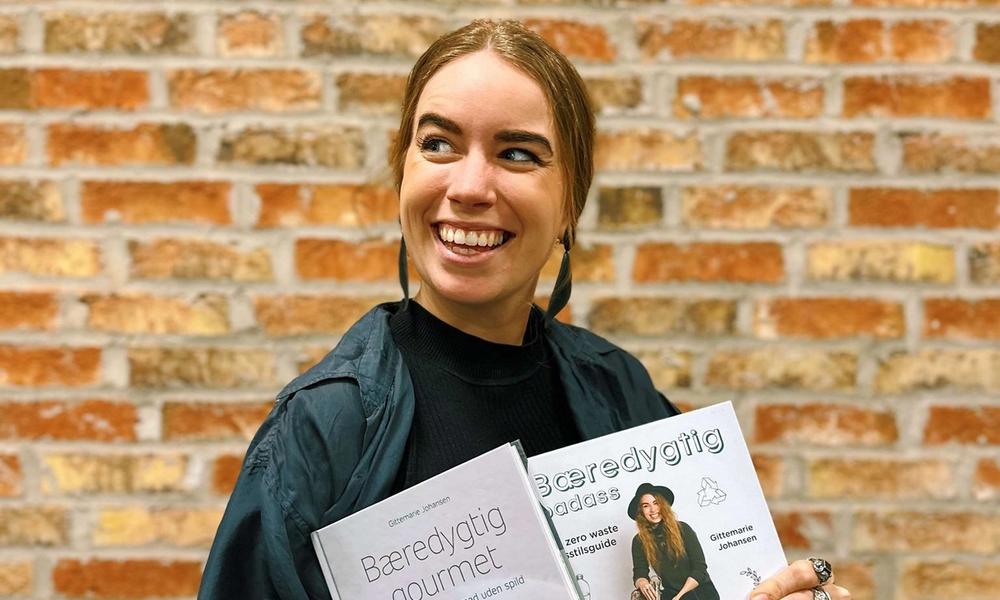 Kvinne holder en bok og smiler