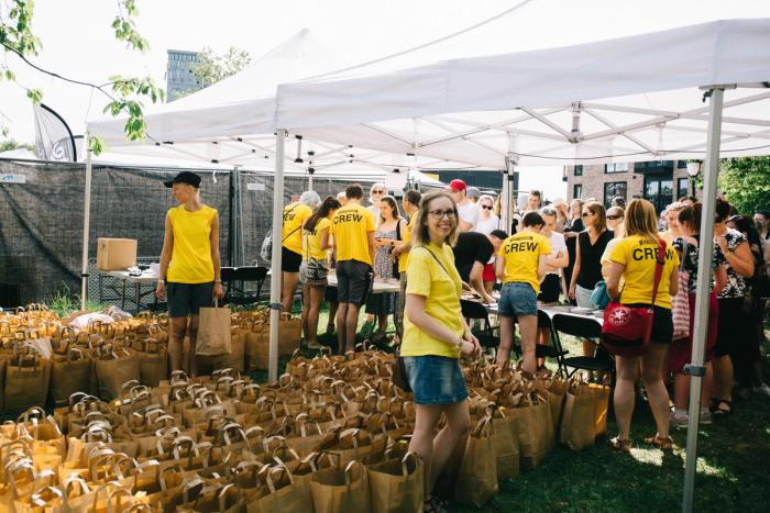 Bilde av frivillig på festivalen som deler ut goodiebags.