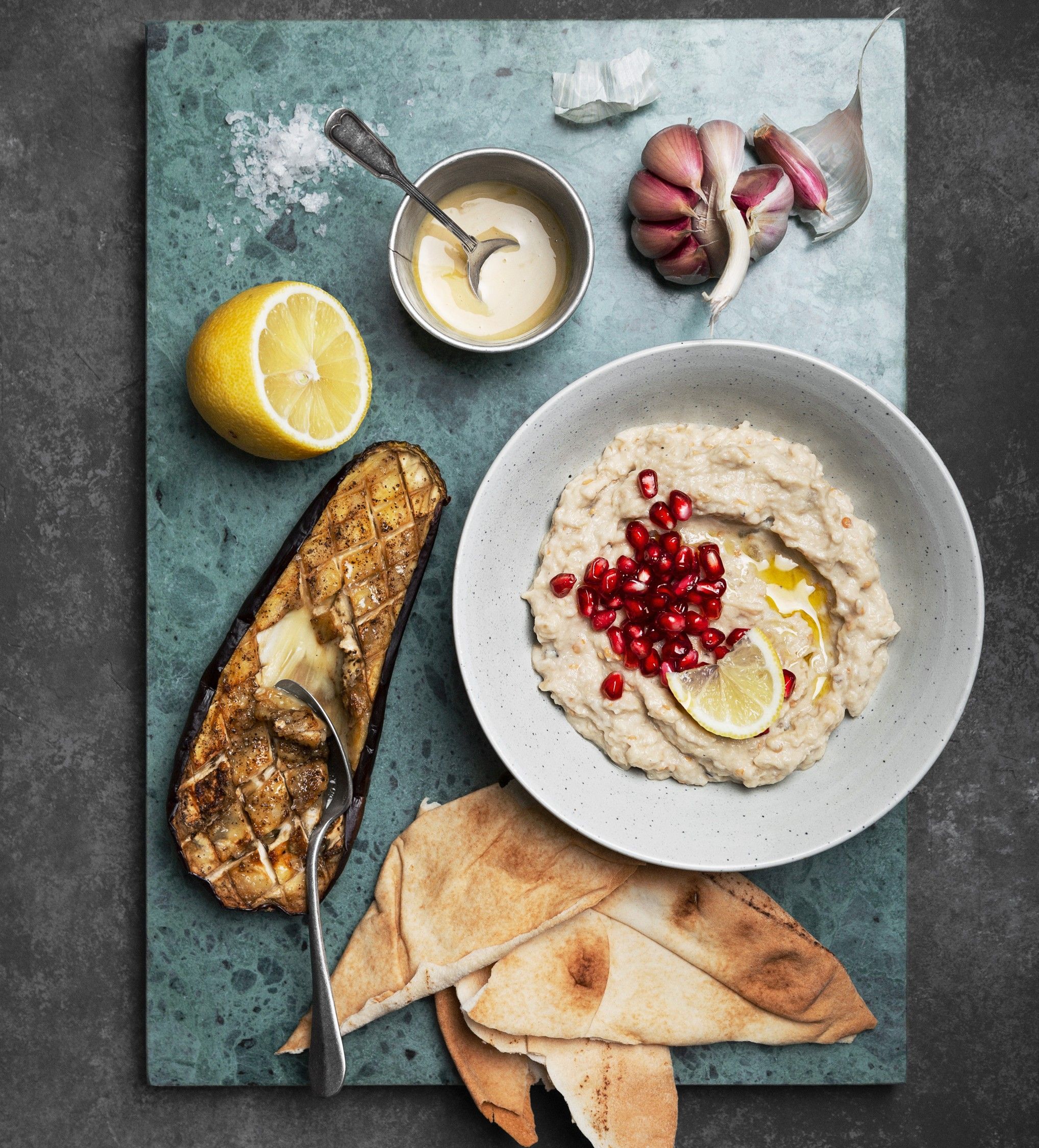 Bilde av en tallerken med baba ghnanoush, aubergine og pitabrød.