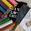 Multi-color glitter heat transfer vinyl rolls displayed alongside custom printed sparkle t-shirts