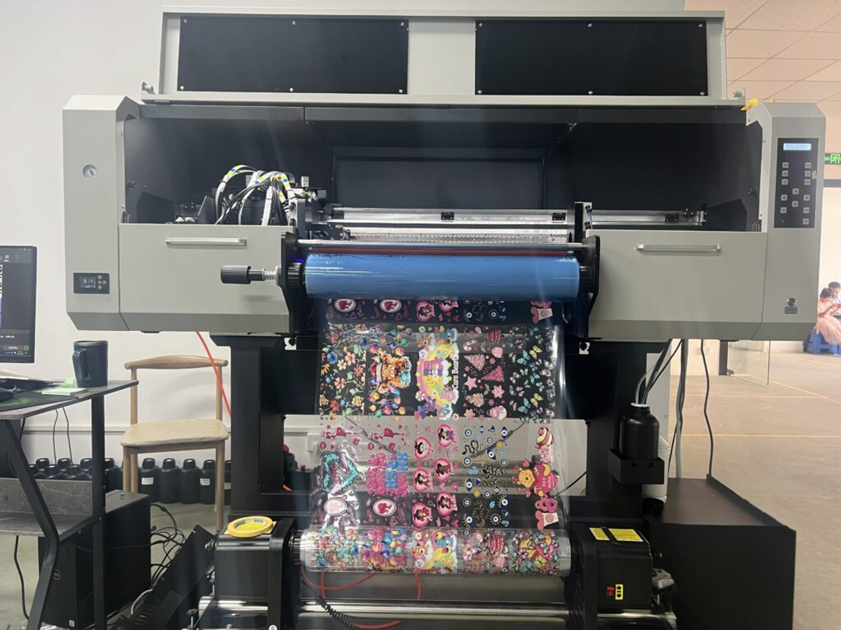 Industrial UV DTF printer machine printing custom perfume bottle labels and transfer stickers in factory