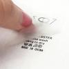 Peeling PET carrier film from printed heat transfer wash care tag on clothing