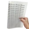 Hand holding clear film sheet with bulk custom reflective heat transfer labels for clothing