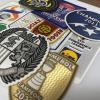 Layered 3D textured flock heat transfer badges showing intricate detail and vibrant color printing