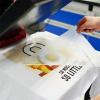 Operating a heat press machine to apply custom screen printed heat transfer PET film onto a t-shirt