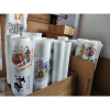 Multiple rolls of custom printed DTF gang sheets packed in boxes for wholesale shipping