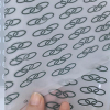 Close-up of peeling clear carrier sheet from printed reflective heat transfer film showing pattern alignment