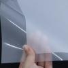 Hand holding premium clear PET DTF film sheet for heat transfer printing