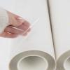 Hand showing the smooth coated surface of a premium PET DTF film roll