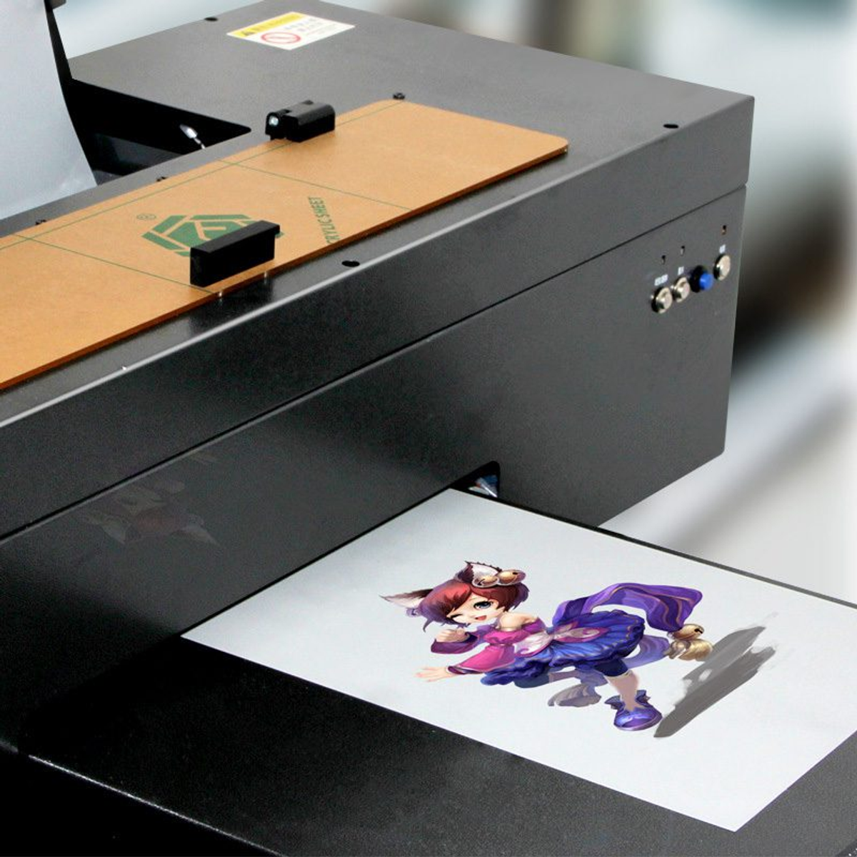 A desktop DTF printer outputting a vibrant color design onto a sheet of DTF transfer film