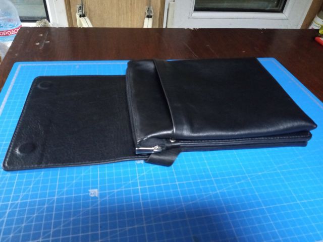 Clutch portadocumenti A4 in pelle nera con maniglia e magneti nascosti su tappetino da taglio blu