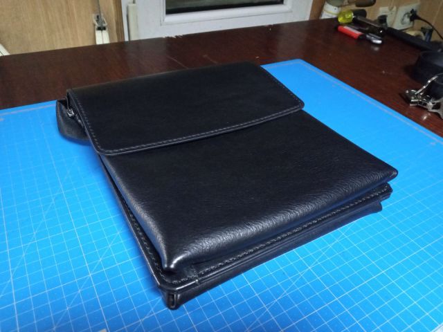 Clutch portadocumenti A4 in pelle nera con maniglia e magneti nascosti su tappetino da taglio blu