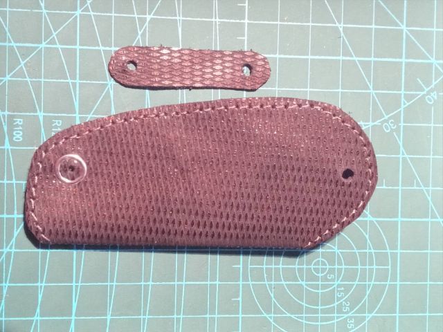 Темний шкіряний чохол для ключів із текстурою та кнопкою, ручна робота, поруч інструмент для шкіри