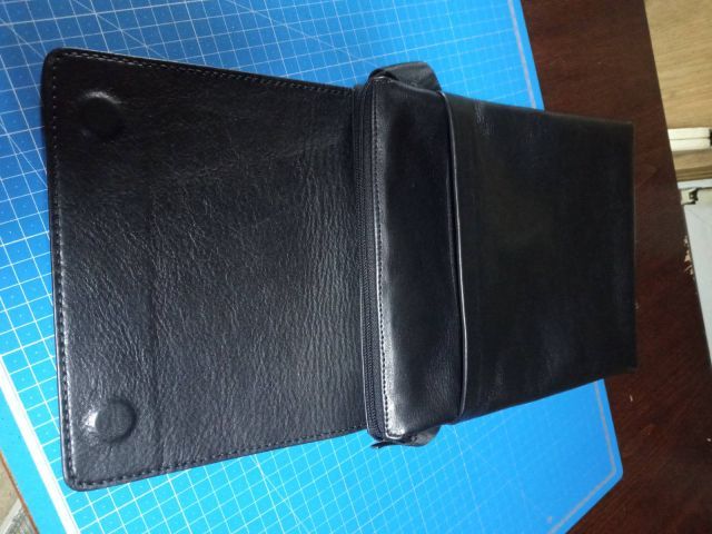 Clutch portadocumenti A4 in pelle nera con maniglia e magneti nascosti su tappetino da taglio blu