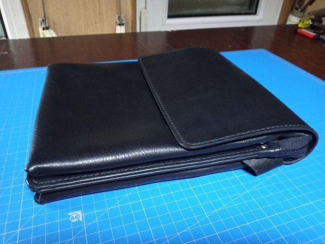 Clutch portadocumenti A4 in pelle nera con maniglia e magneti nascosti su tappetino da taglio blu
