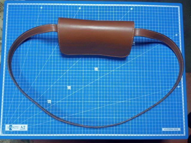 Коричнева шкіряна міні-сумка crossbody з клапаном на магніті та довгим ремінцем, фото на килимку для різання