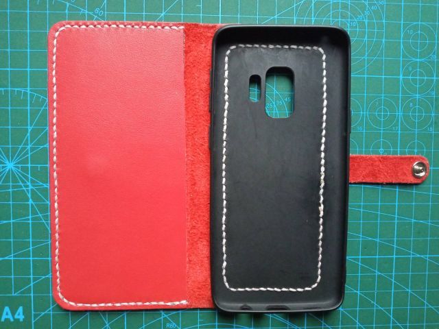 Червоний шкіряний чохол-книжка для смартфона з ремінцем на кнопці та білою строчкою, ручна робота