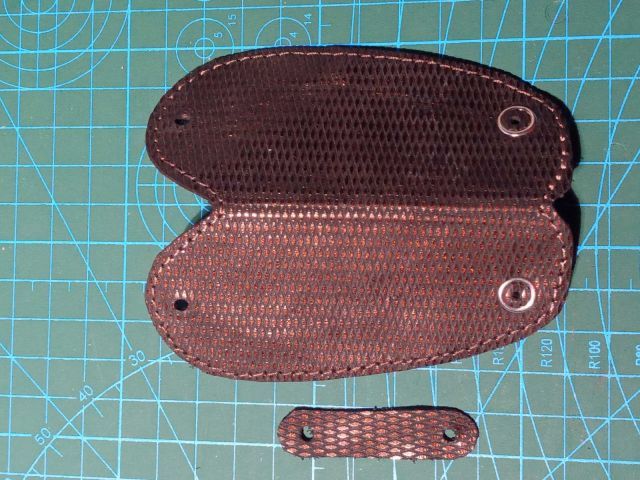 Темний шкіряний чохол для ключів із текстурою та кнопкою, ручна робота, поруч інструмент для шкіри