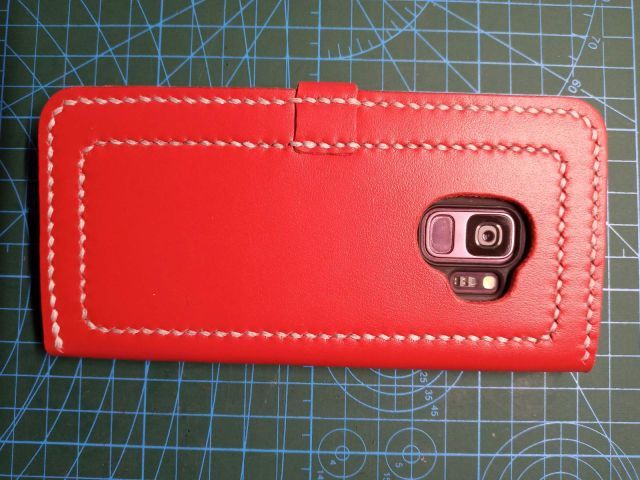 Червоний шкіряний чохол-книжка для смартфона з ремінцем на кнопці та білою строчкою, ручна робота