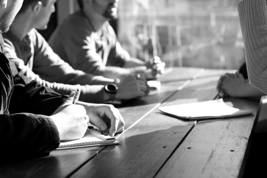 A team at a long table, writing