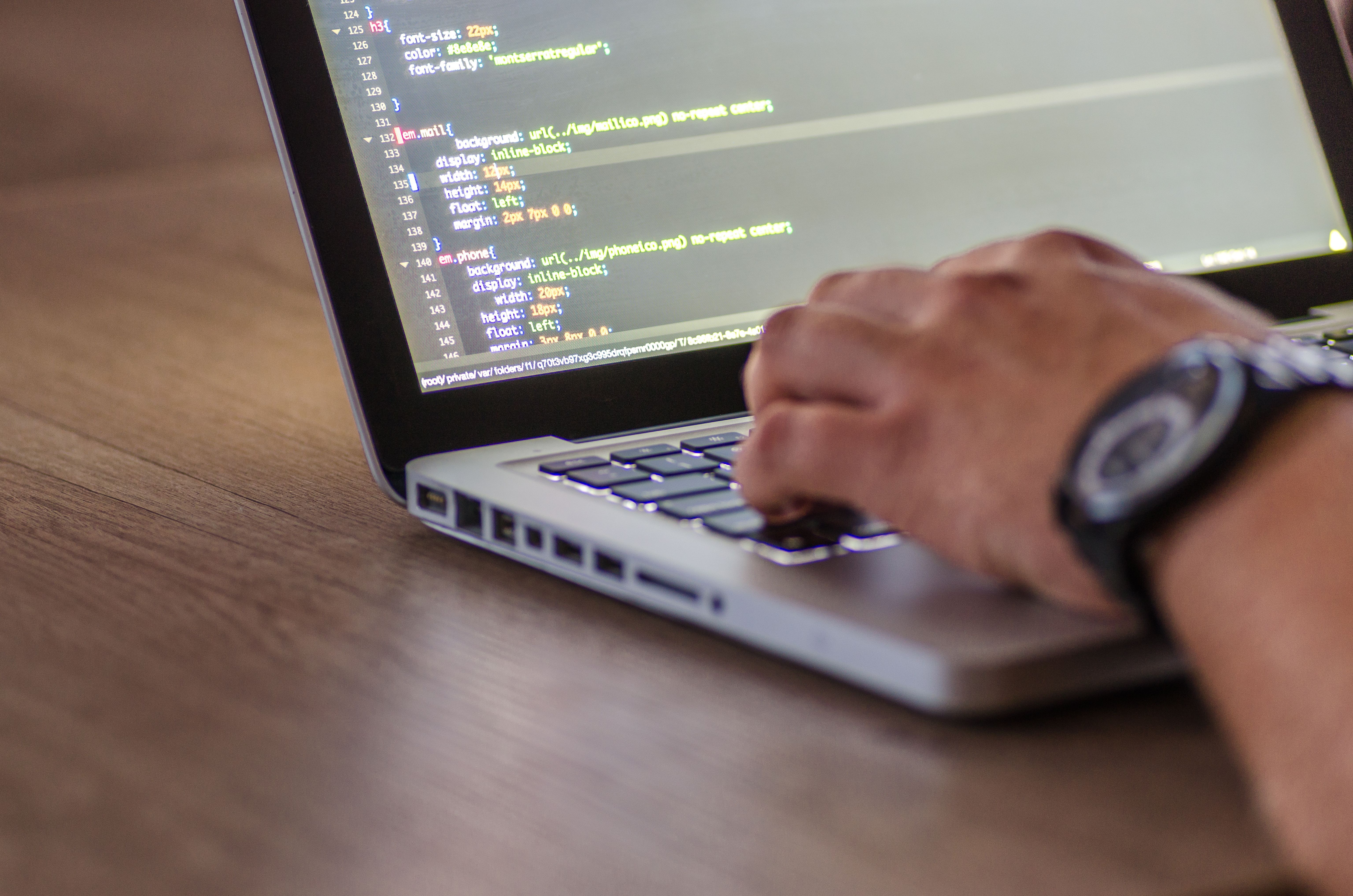 Developer writing code on a laptop screen