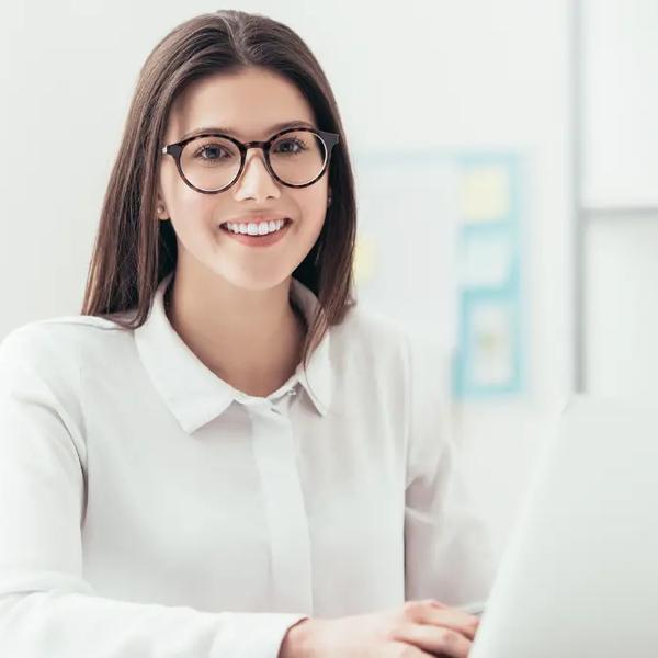 Analyst in glasses working at a laptop in a bright office