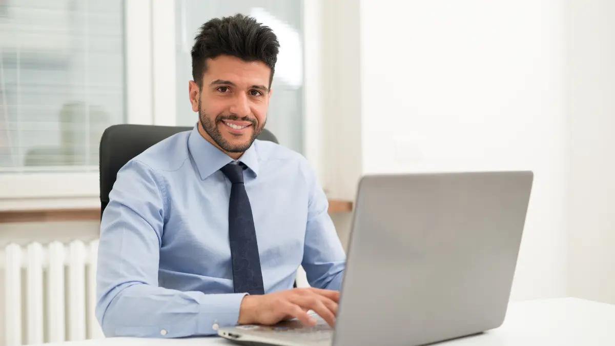Man in a shirt and tie working at a laptop in an office