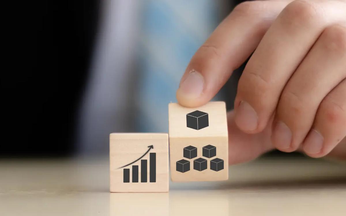 Hand turning wooden blocks printed with a growth chart and a cluster of cubes