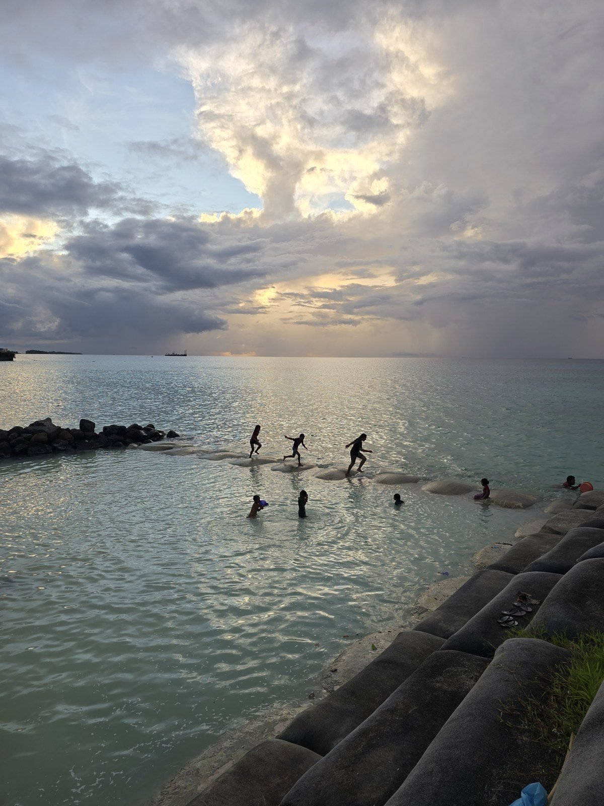 Kids playing in the lagoon off the causeway at sunset