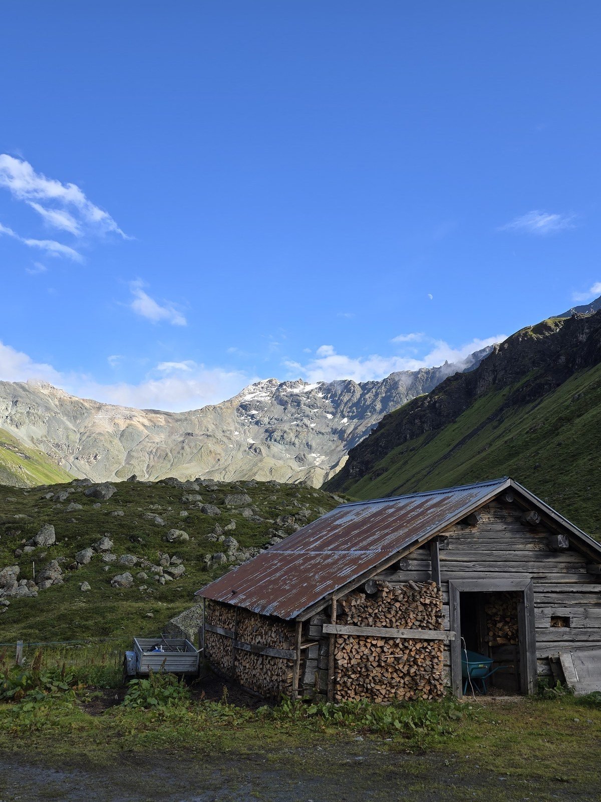 A woodshed on the alp with the pass ridge behind