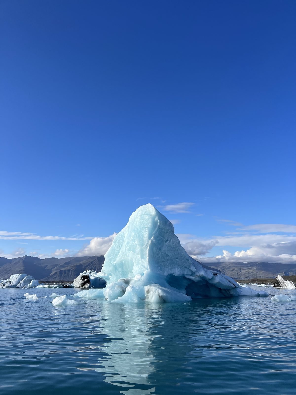 A blue-white iceberg glowing in the sunlight on the glacier lagoon