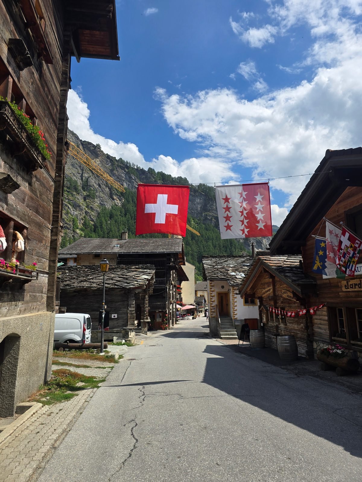 Evolène's old street under Swiss and Valais flags, the end of the route