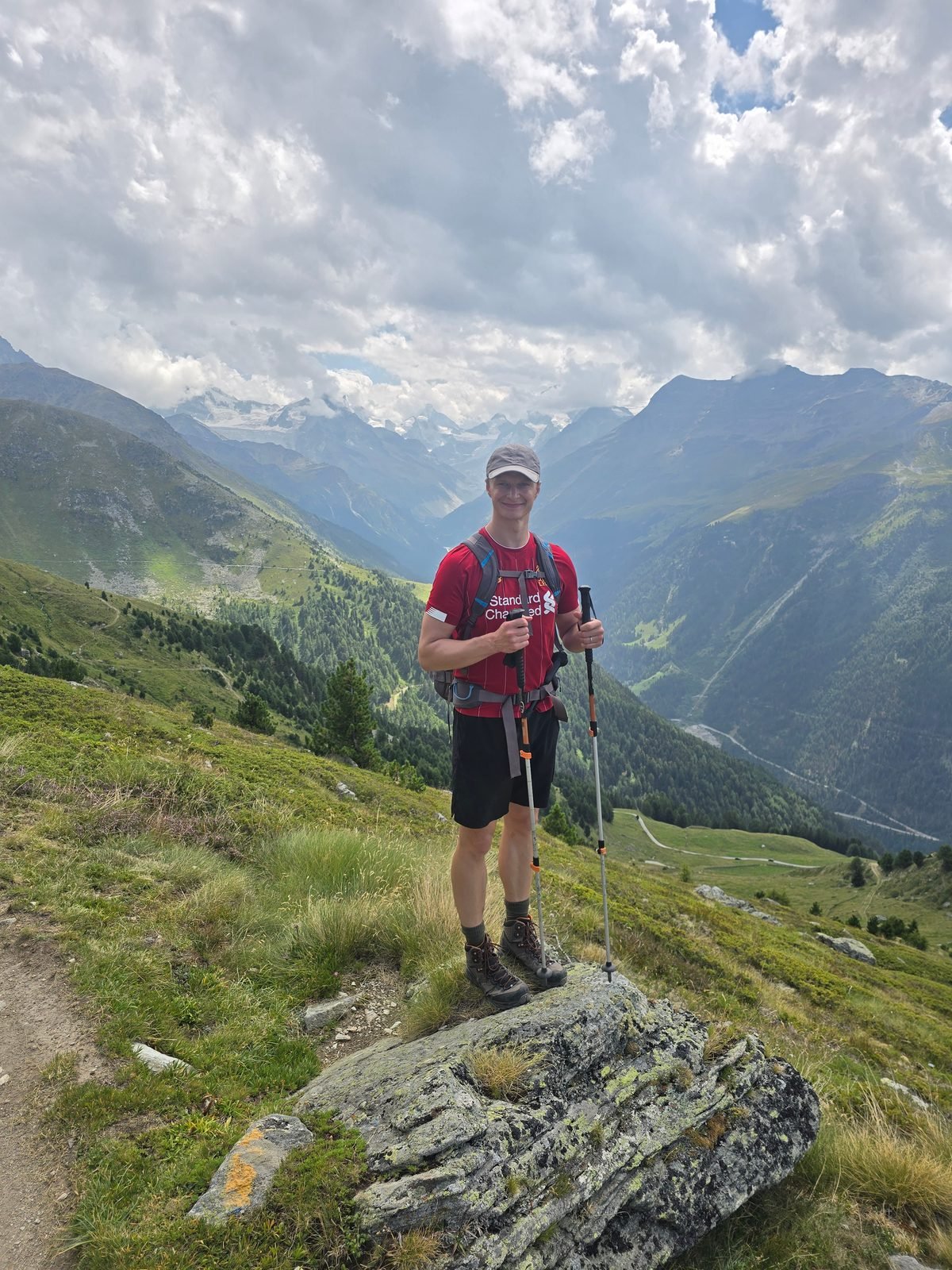 Hiker above the Val d'Anniviers with 4,000-metre peaks across the valley