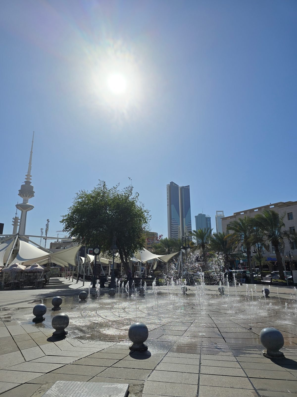 The corniche promenade into the low sun below Kuwait Towers