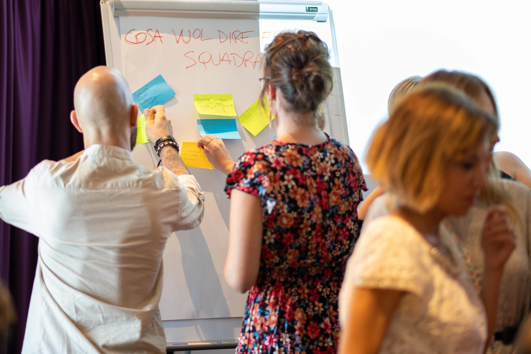 Uomo che parla di fronte ad un pubblico seduto