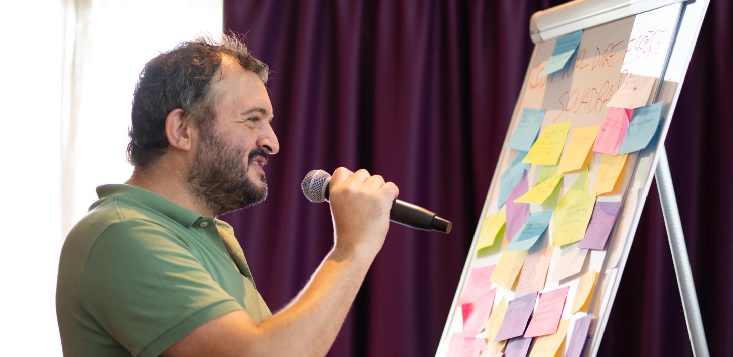 Un uomo che parla davanti a delle persone sedute