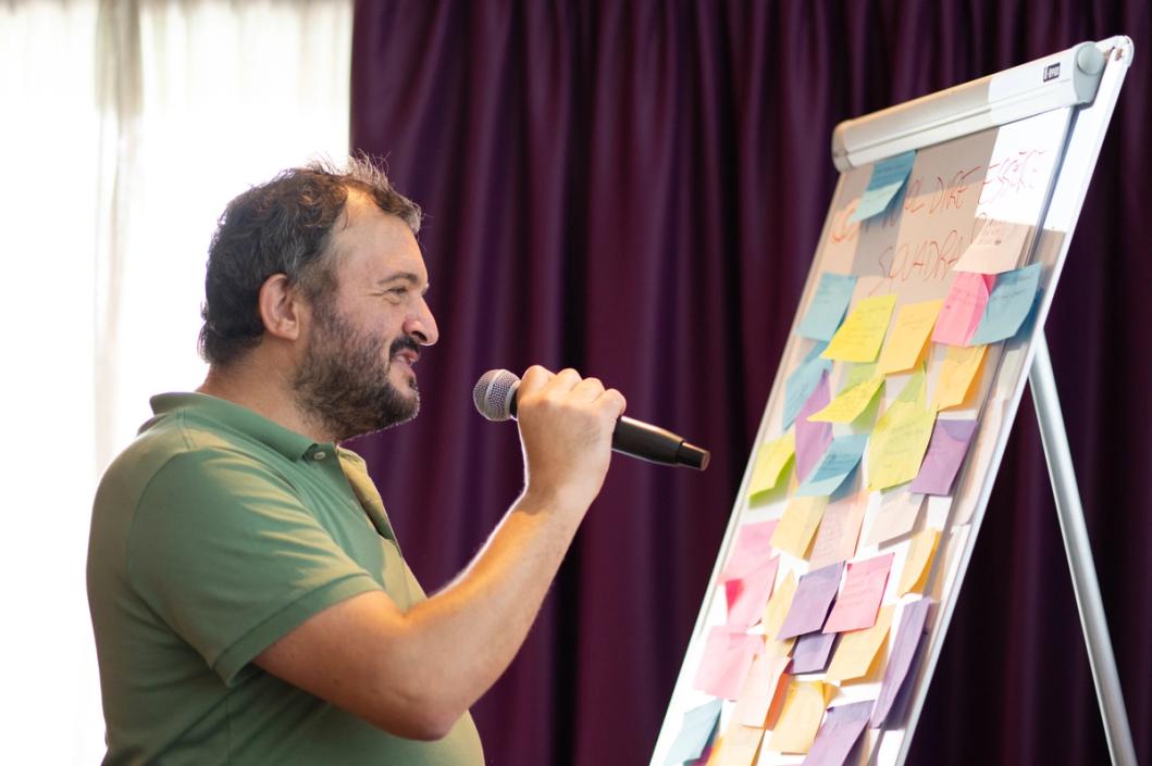 Un uomo che parla davanti a delle persone sedute