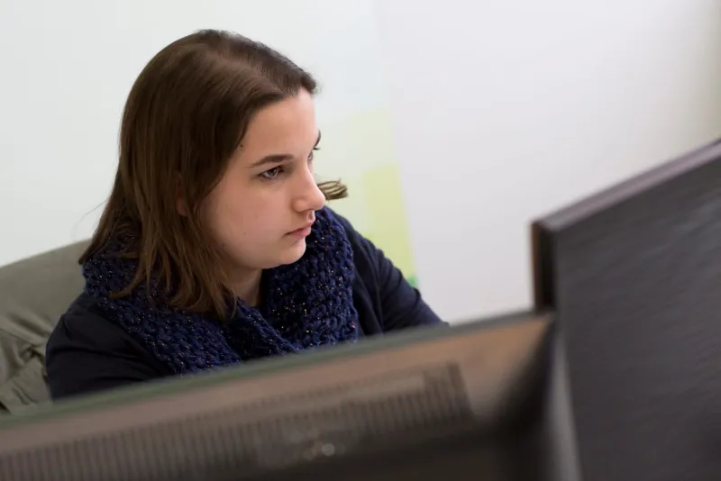 Elise Féty concentrée devant son écran pendant ses années en agence web, en tant que développeuse front-end
