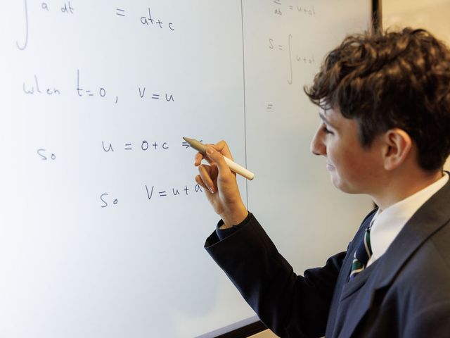Solving a maths problem on a white board