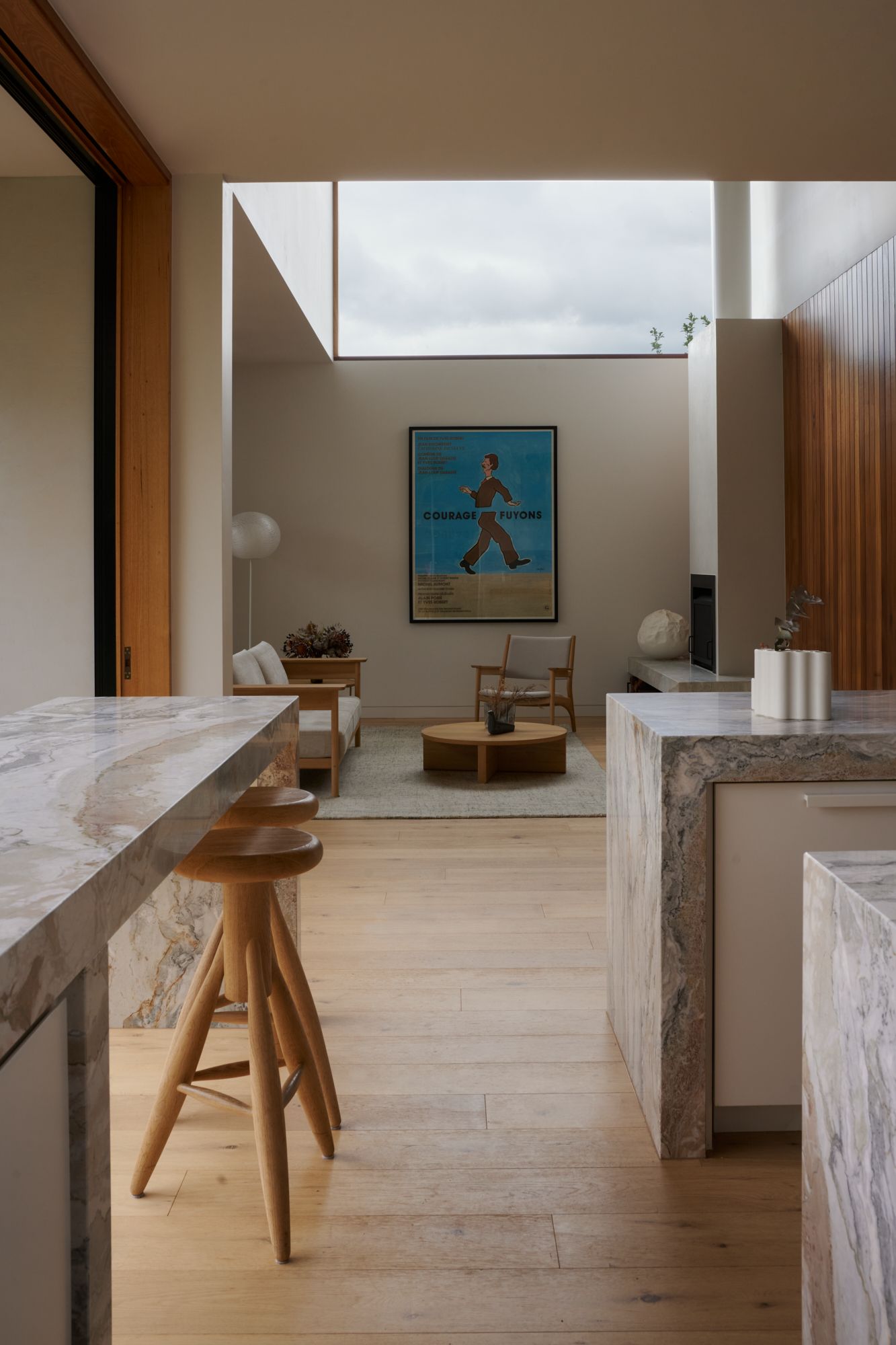 An elevation view of the kitchen looking into the living room. With a large window above.  | College Street by RCA Studio and Built By Manor | Hawthorn | Veeral Patel
