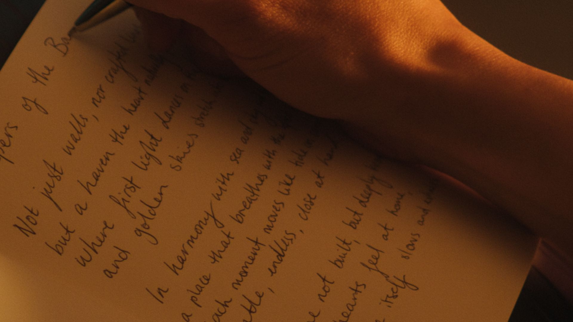 A person writing a poem inside a notebook.  The International, Brighton developed by Landream & V-Leader | Architecture by Carr | Architectural Film by Veeral Patel