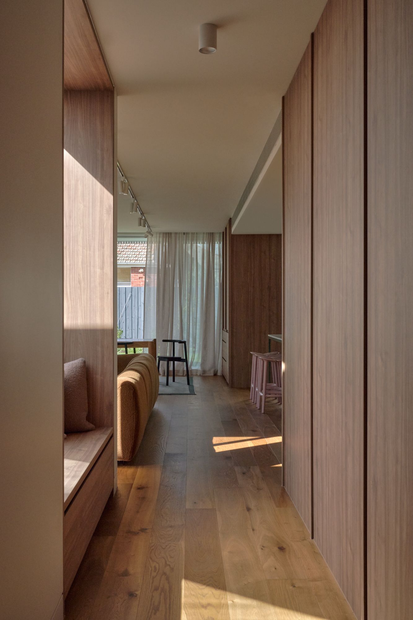 Inside the new contemporary space, with an integrated day bed on the left and a view of the dinning and kitchen spaces.| Peavey Residence II by FYC Architects and Snakes & Ladders Projects | Prahran | Veeral Patel