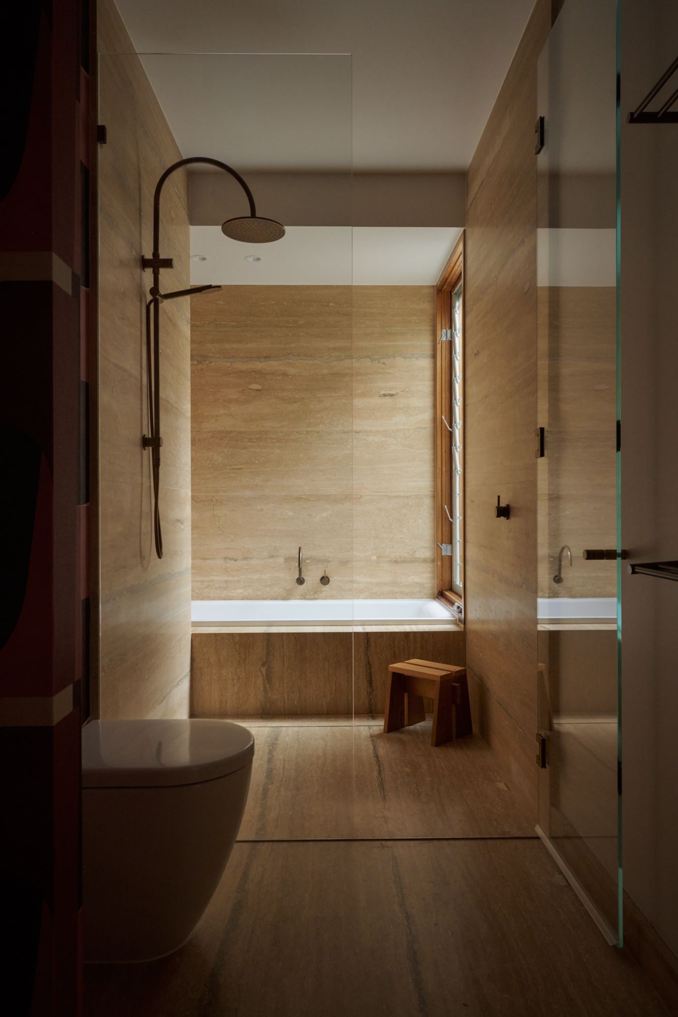 An elevation view of the bathroom with shower and bath tub. With floor to ceiling in travertine.   | College Street by RCA Studio and Built By Manor | Hawthorn | Veeral Patel