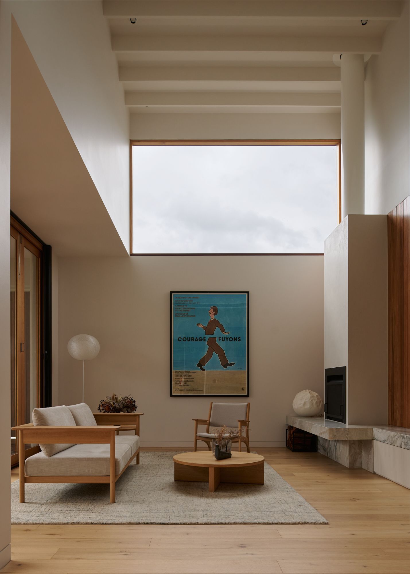 An elevation view of the living room, showing the double height, with large window above and the flue running towards the ceiling with Japanese themed furniture.   | College Street by RCA Studio and Built By Manor | Hawthorn | Veeral Patel