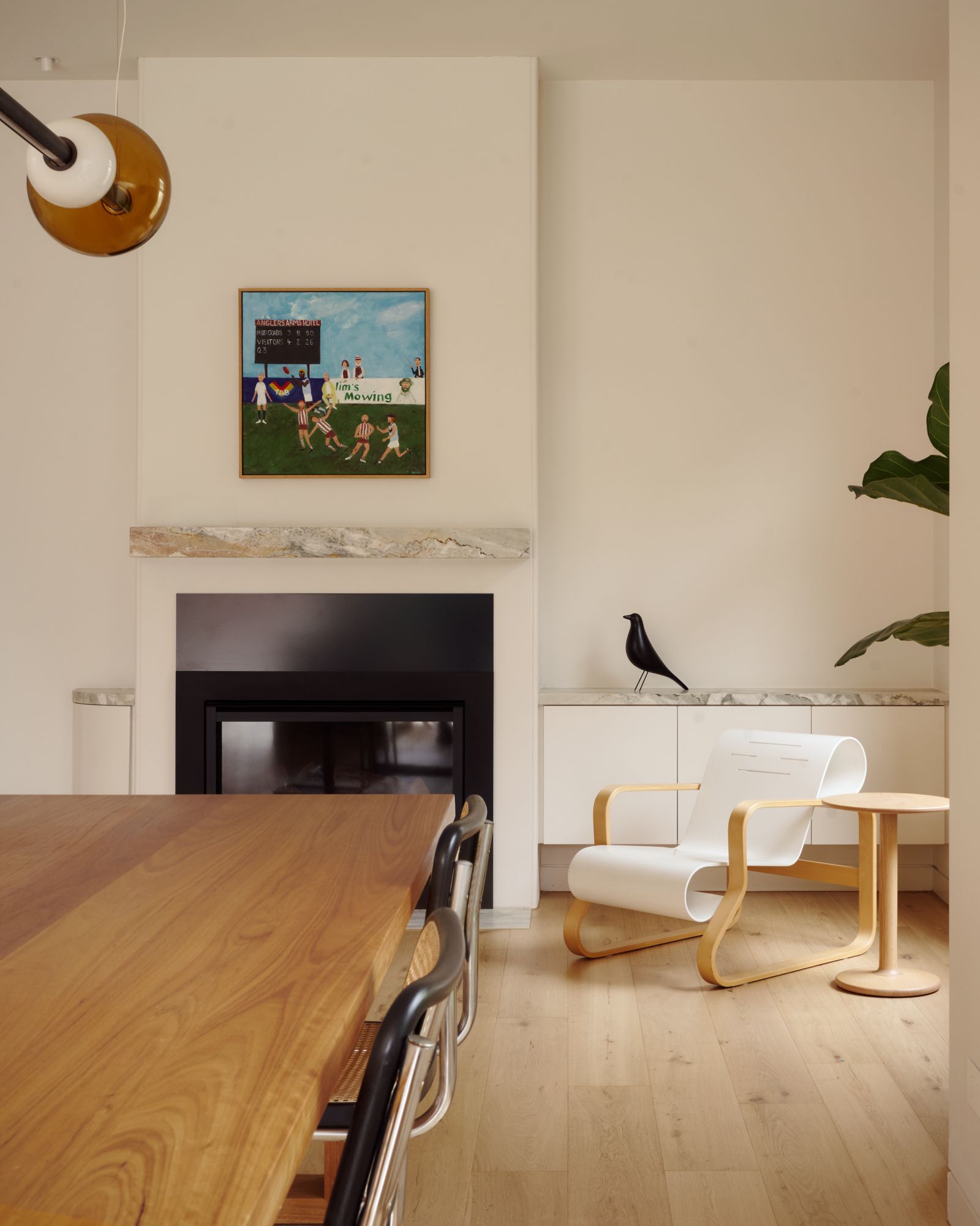 A portion of the dining table looking towards the back of the house with the fireplace.   | College Street by RCA Studio and Built By Manor | Hawthorn | Veeral Patel