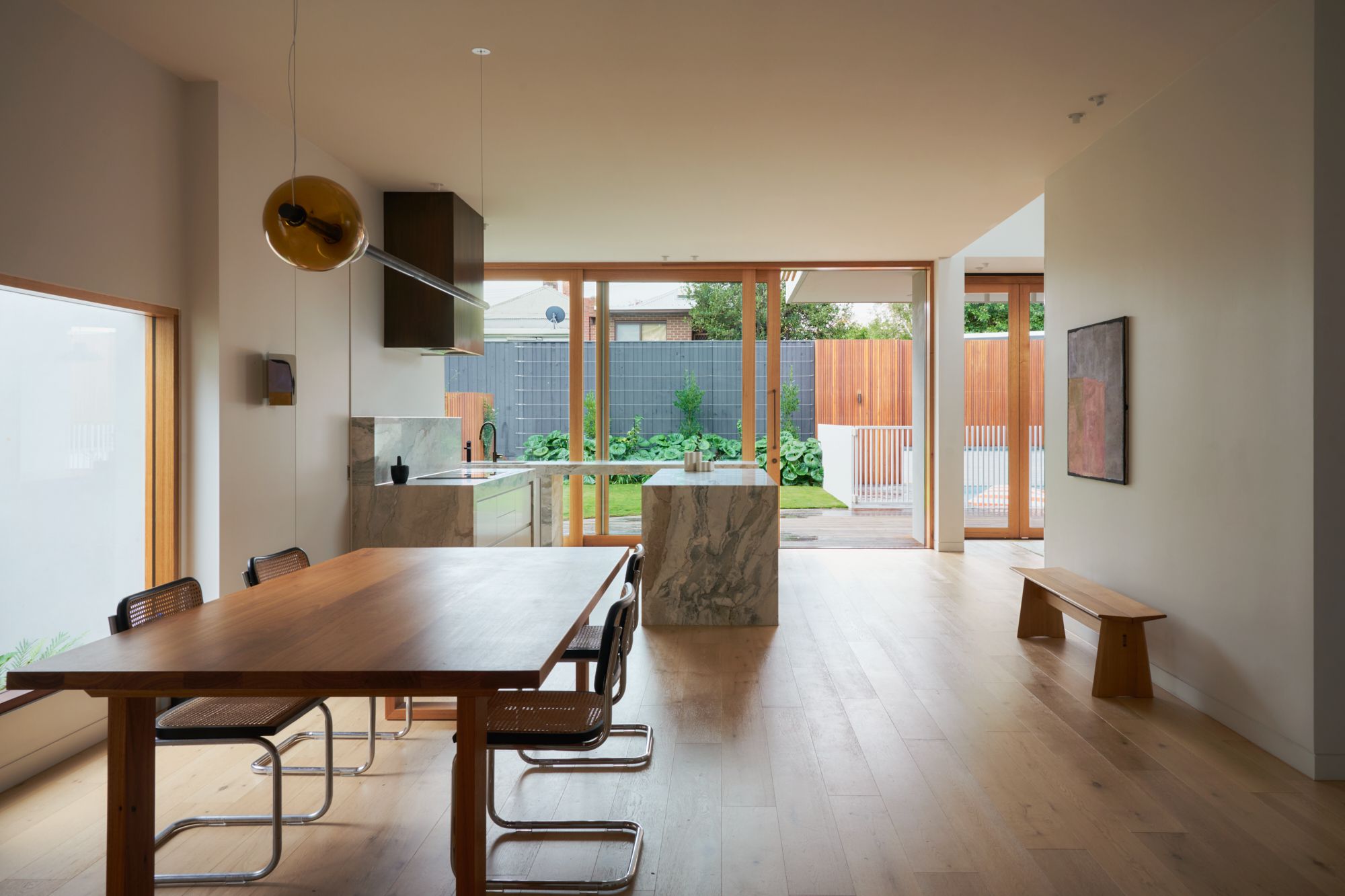An elevation view of the dining room and the kitchen looking into the backyard.  | College Street by RCA Studio and Built By Manor | Hawthorn | Veeral Patel