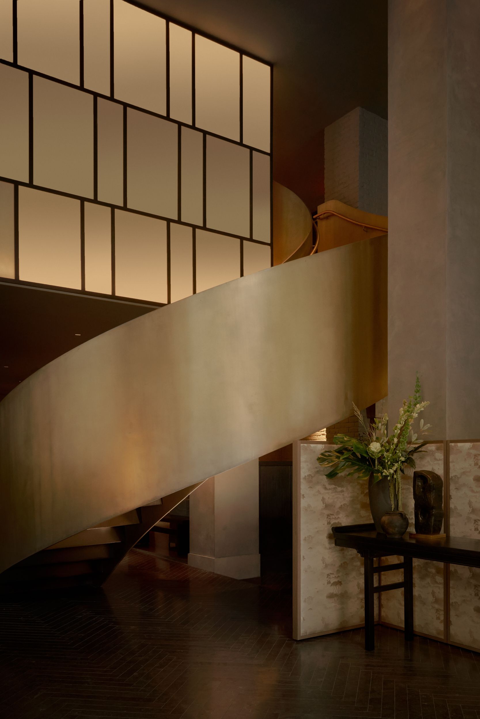 A close up detail of the curved bronze staircase and the Japanese inspired screen. The bar of AKA Nomad, featuring the triple height chandelier. | AKA Hotel Nomad, New York | Architecture and Interiors by Lissoni Partners | Photography by Veeral Patel 